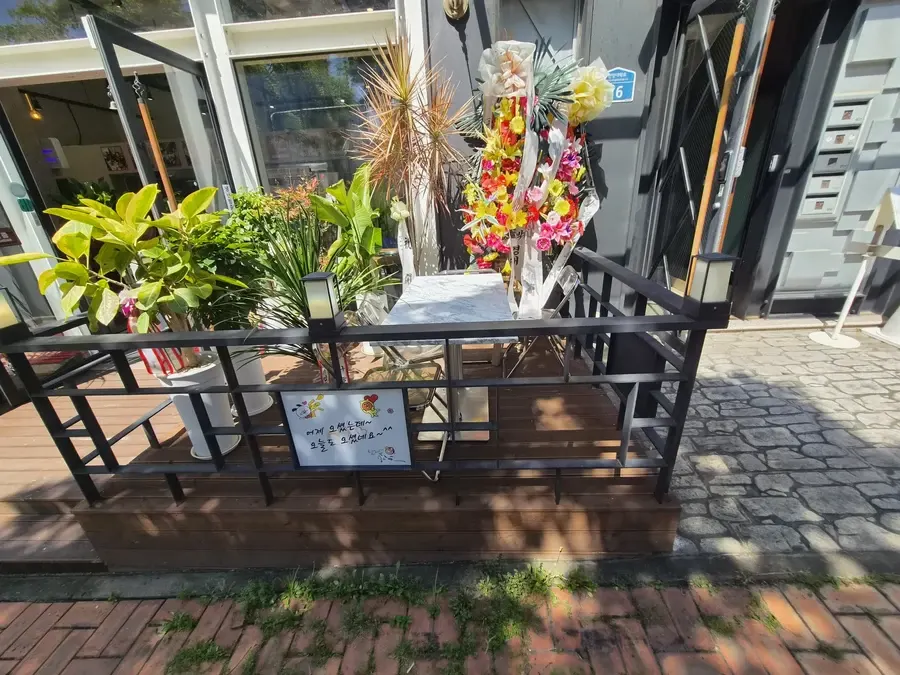 안산 식당 데크에 난간과 전등을 추가하고 화분과 테이블을 둔 모습